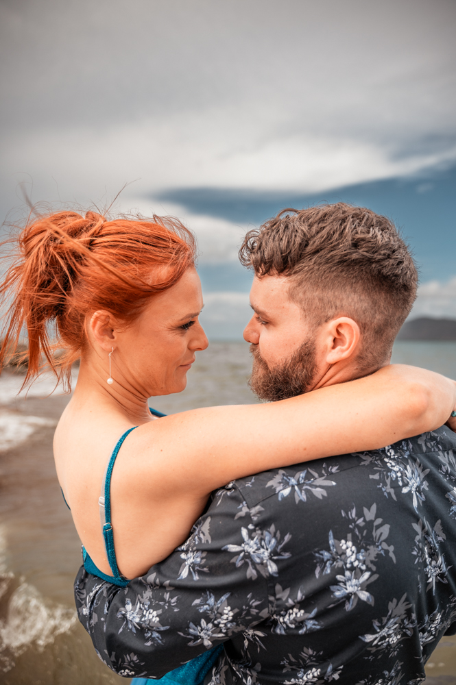 man and woman and the beach staring deeply in to each others eyes - engagement photography by Jamie Simmons
