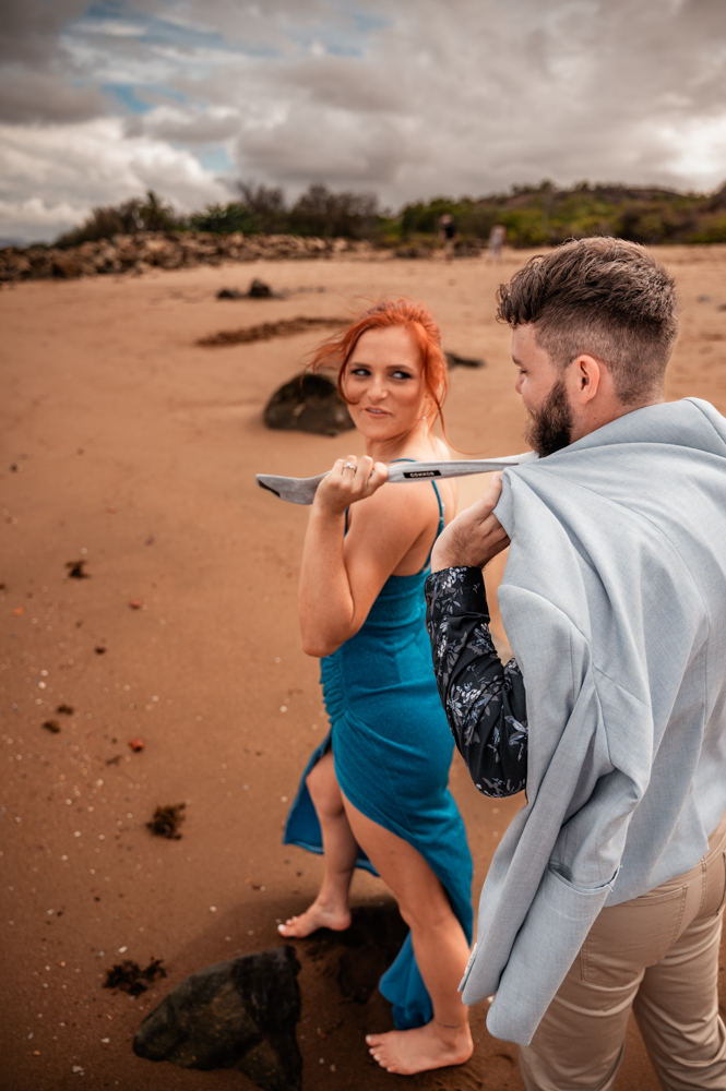 woman dragging fiancé by his tie while looking over her shoulder smiling - engagement photography by Jamie Simmons