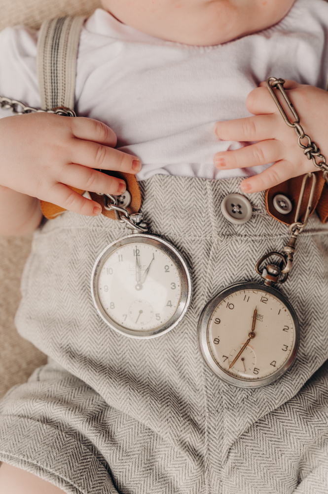 close up shot of newborn holding family heirloom pocket watches - newborn photography by Jamie Simmons