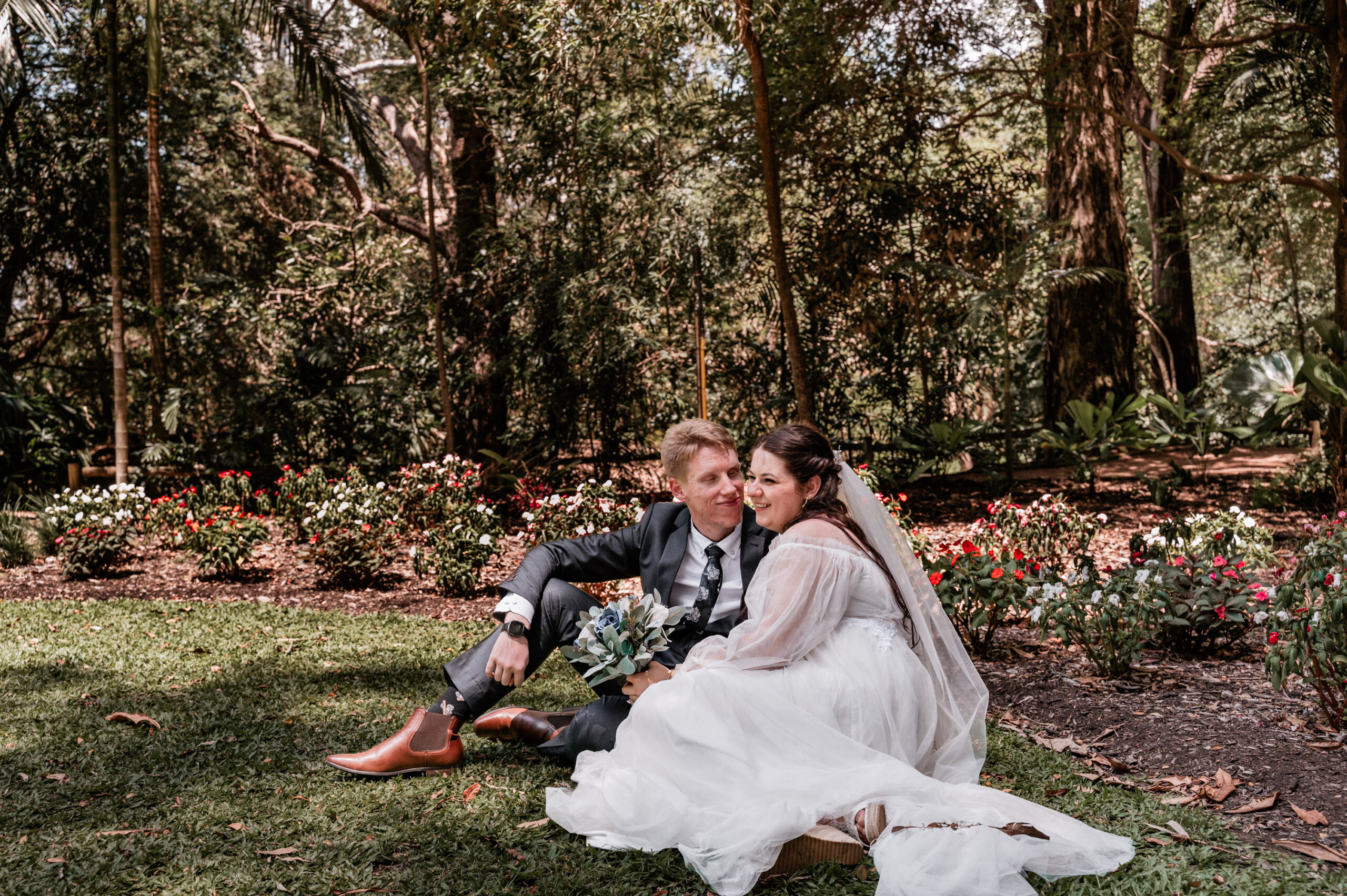 husband and wife sitting in a Townsville Botanical Garden after Wedding