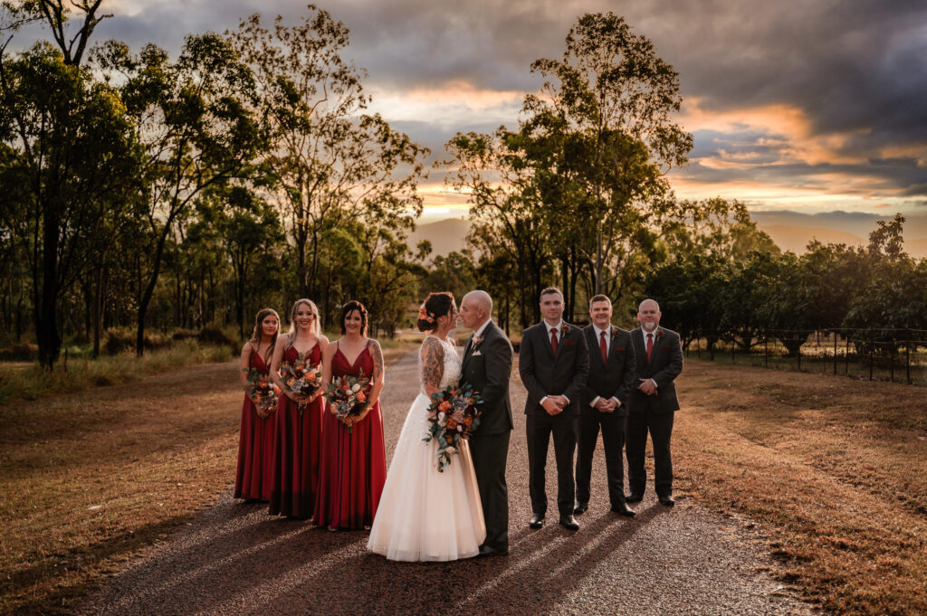 bridal party on outback townsville road at sunset during wedding day - wedding photography by Jamie Simmons
