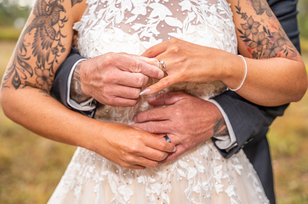 townsville bride and groom embracing while putting on their wedding rings - wedding photography by Jamie Simmons